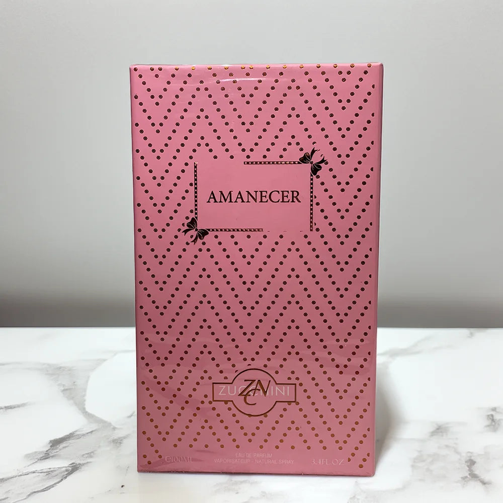 Pink packaging box with 'Amanecer' branding on a marble surface